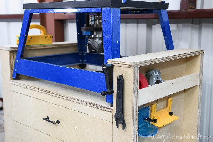 Right side of the router table showing a space beneath the raised ledge for the router lift crank, along with a hook for storing the wrenches.