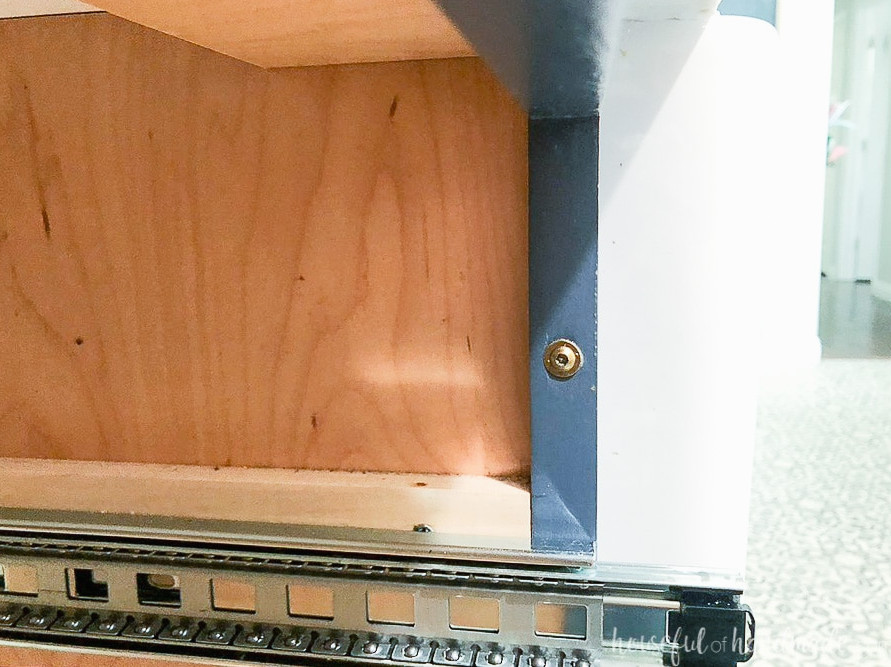 Close up view of the cabinet screw in the side of the face frame holding the cabinets together.
