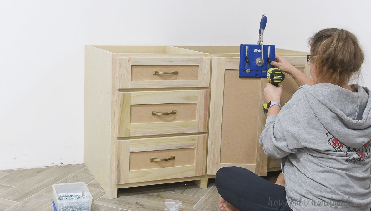 Drilling a hole for the cabinet door knob with a jig.