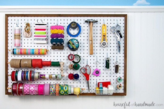 Create the perfect place to organize your most used supplies! Learn how to hang pegboard so it is removable if needed. Housefulofhandmade.com | Craft organization ideas | Craft room remodel | Pegboard organization | $100 Room Challenge | Easy woodworking | Easy building plans | Free Building plans