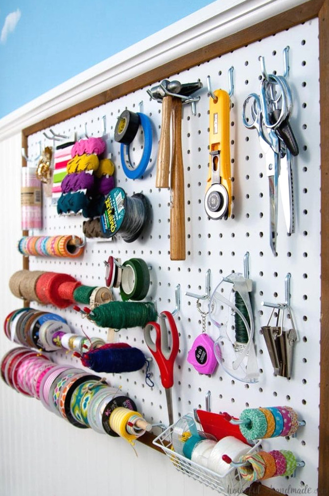 Create the perfect place to organize your most used supplies! Learn how to hang pegboard so it is removable if needed. Housefulofhandmade.com | Craft organization ideas | Craft room remodel | Pegboard organization | $100 Room Challenge | Easy woodworking | Easy building plans | Free Building plans