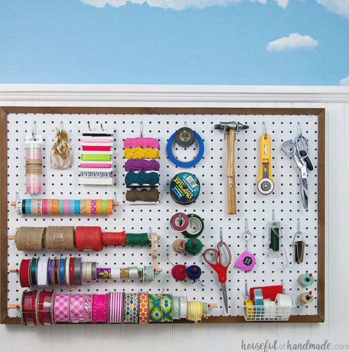Create the perfect place to organize your most used supplies! Learn how to hang pegboard so it is removable if needed. Housefulofhandmade.com | Craft organization ideas | Craft room remodel | Pegboard organization | $100 Room Challenge | Easy woodworking | Easy building plans | Free Building plans