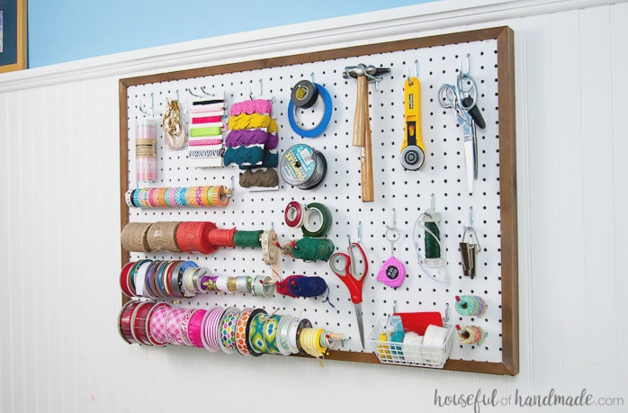 Create the perfect place to organize your most used supplies! Learn how to hang pegboard so it is removable if needed. Housefulofhandmade.com | Craft organization ideas | Craft room remodel | Pegboard organization | $100 Room Challenge | Easy woodworking | Easy building plans | Free Building plans