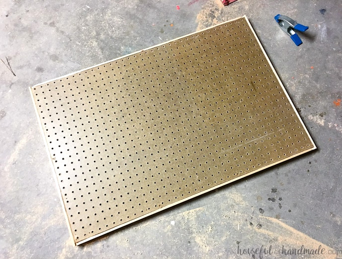 Create the perfect place to organize your most used supplies! Learn how to hang pegboard so it is removable if needed. Housefulofhandmade.com | Craft organization ideas | Craft room remodel | Pegboard organization | $100 Room Challenge | Easy woodworking | Easy building plans | Free Building plans