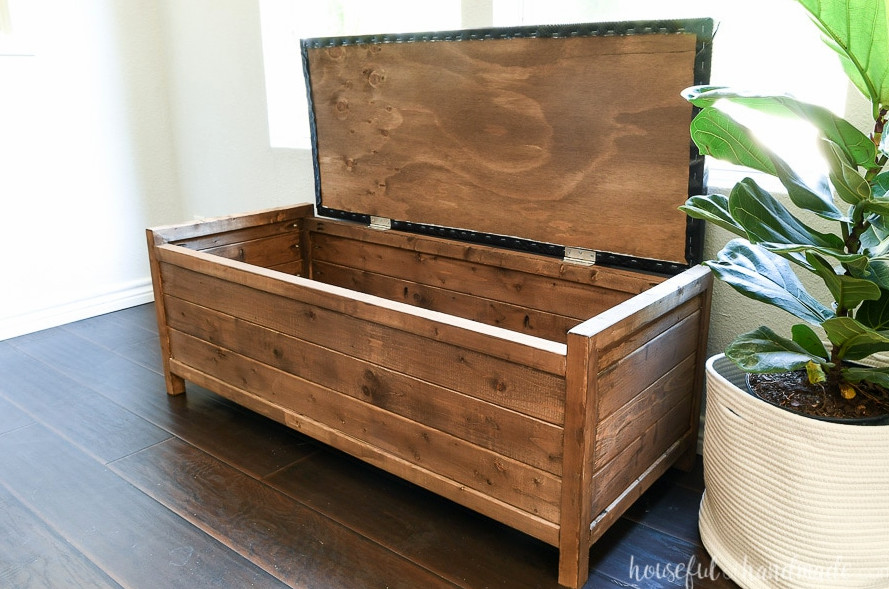 Brown wooden storage bench with the lid raised to reveal its roomy storage compartment.