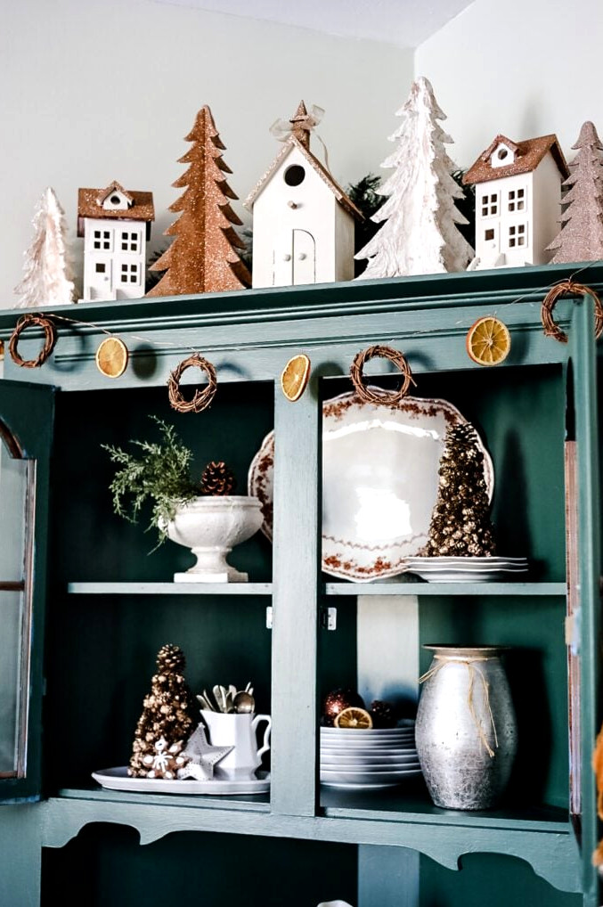 green hutch decorated for christmas with orange garland