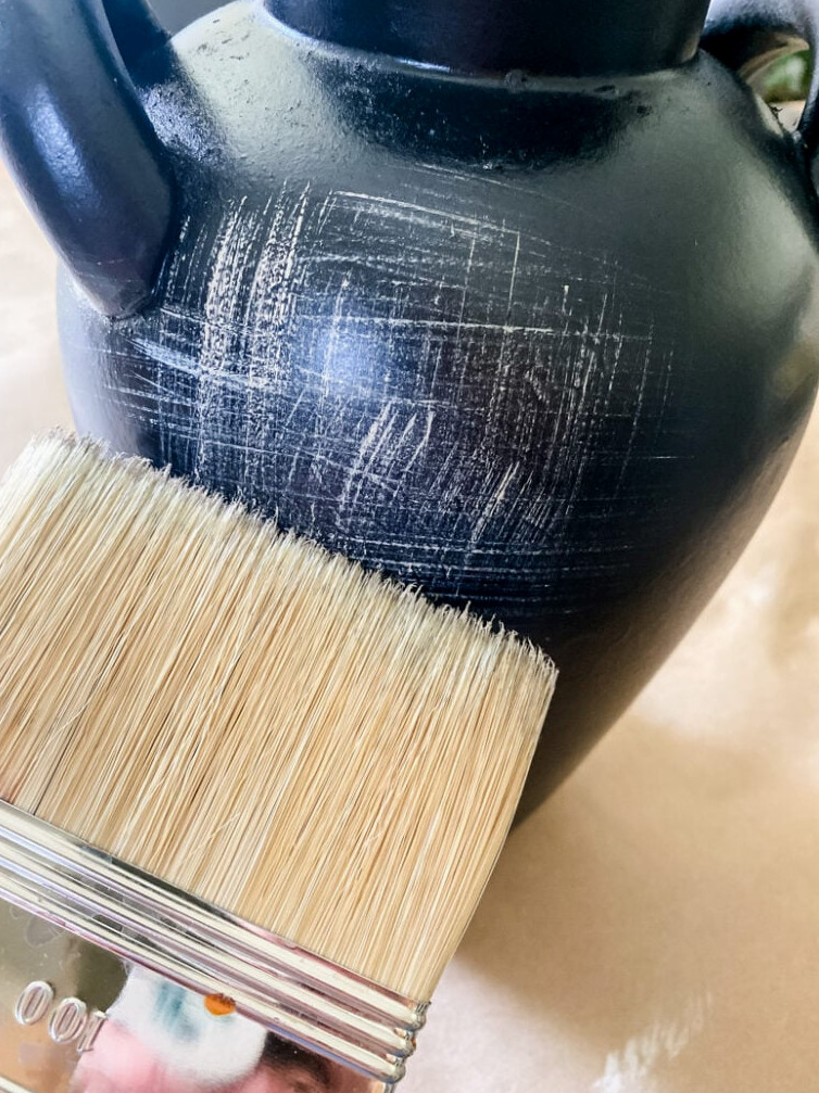 painting cream paint details on vase