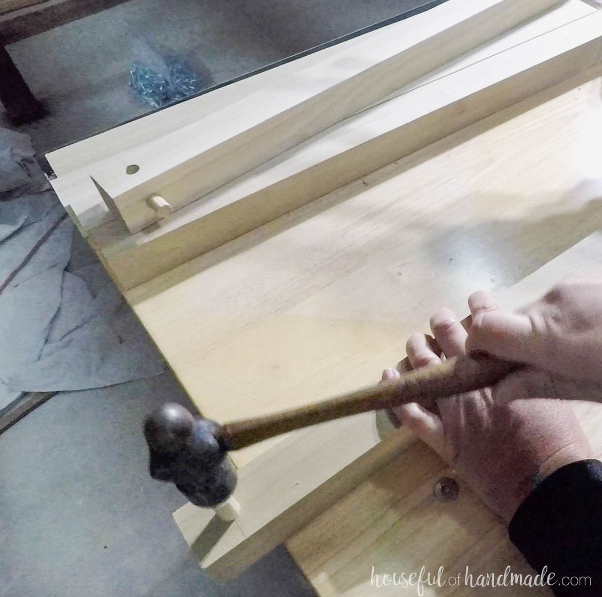 Tapping dowel into hole with a hammer.