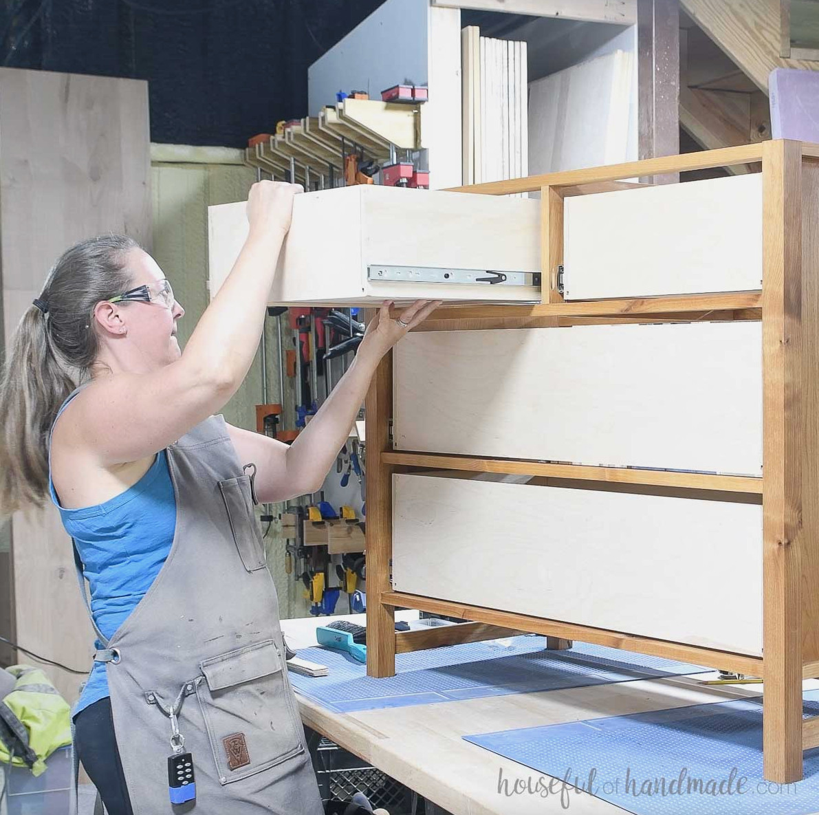 Guiding the drawer into the dresser to connect the slides. 