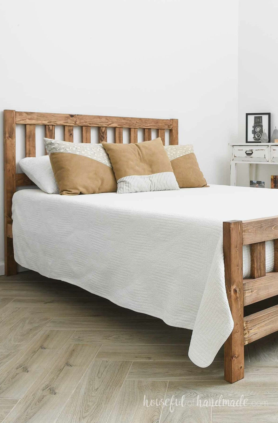 Beautiful mission style DIY bed with white comforter and leather pillows.