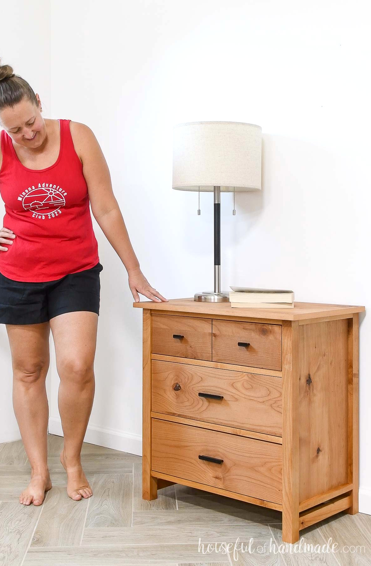 Kati standing beside the 3 drawer nightstand she constructed. 