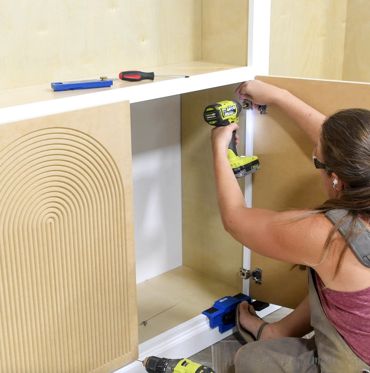 Installing the doors onto the cabinet face frame with overlay hinges.