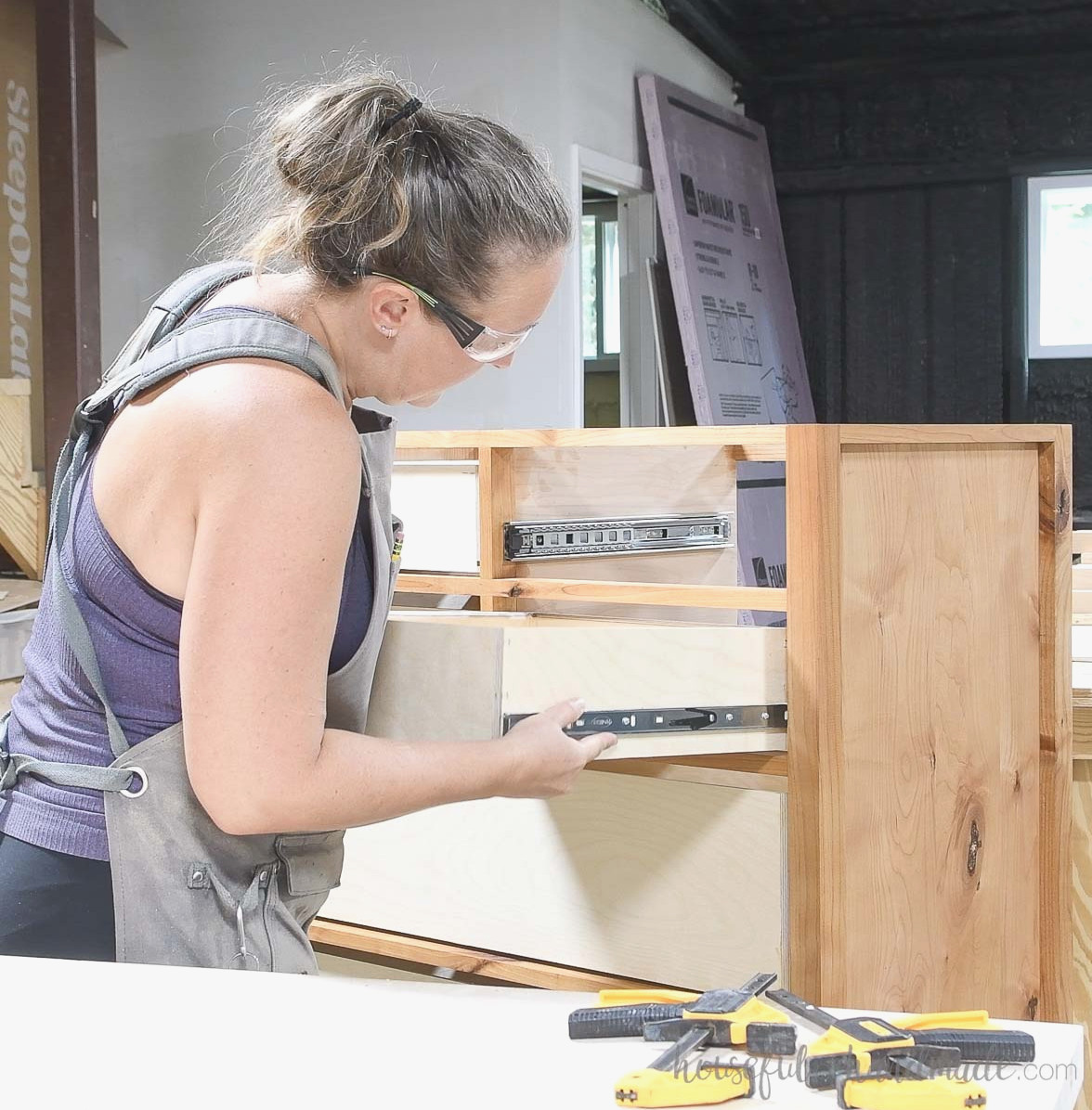 Sliding a drawer box into the dresser using drawer slides.
