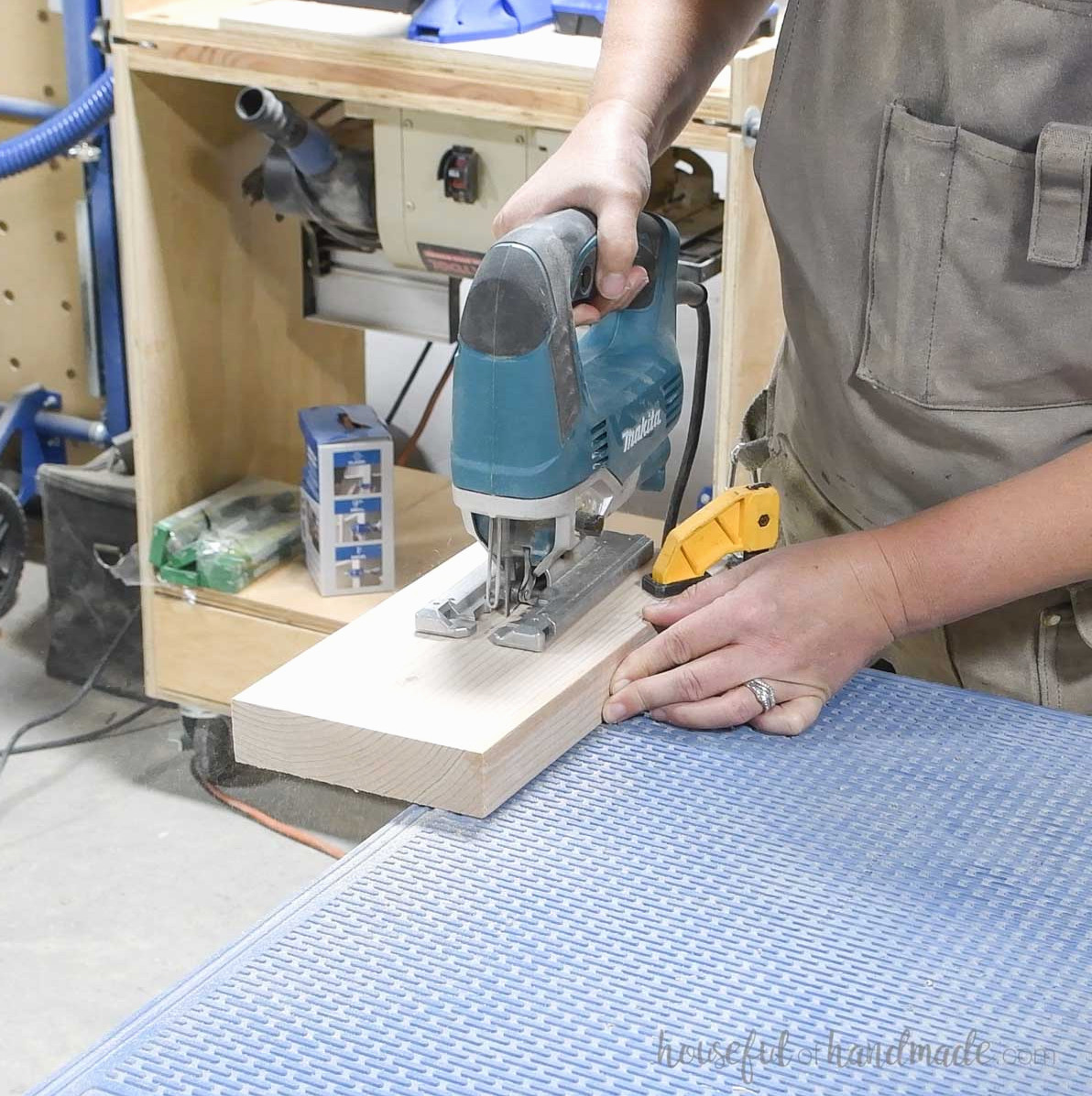 Cutting a curve on a board with a jigsaw.