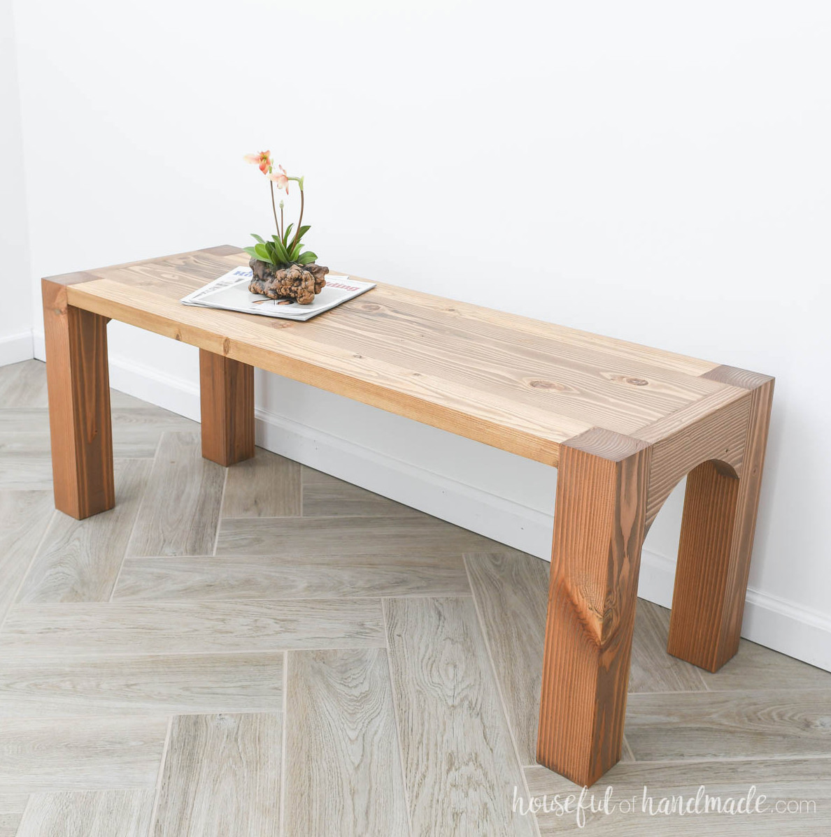 Wood coffee table with legs that show on top and arches on the sides.