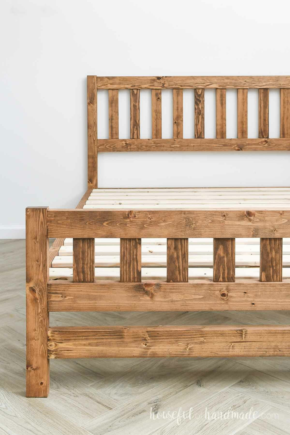 Platform bed with headboard and footboard and no mattress so you can see the bed slats and frame.