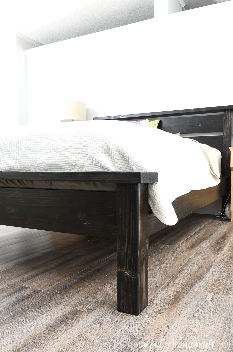 Side perspective of the black queen bed frame, featuring a headboard and footboard built from affordable lumber.