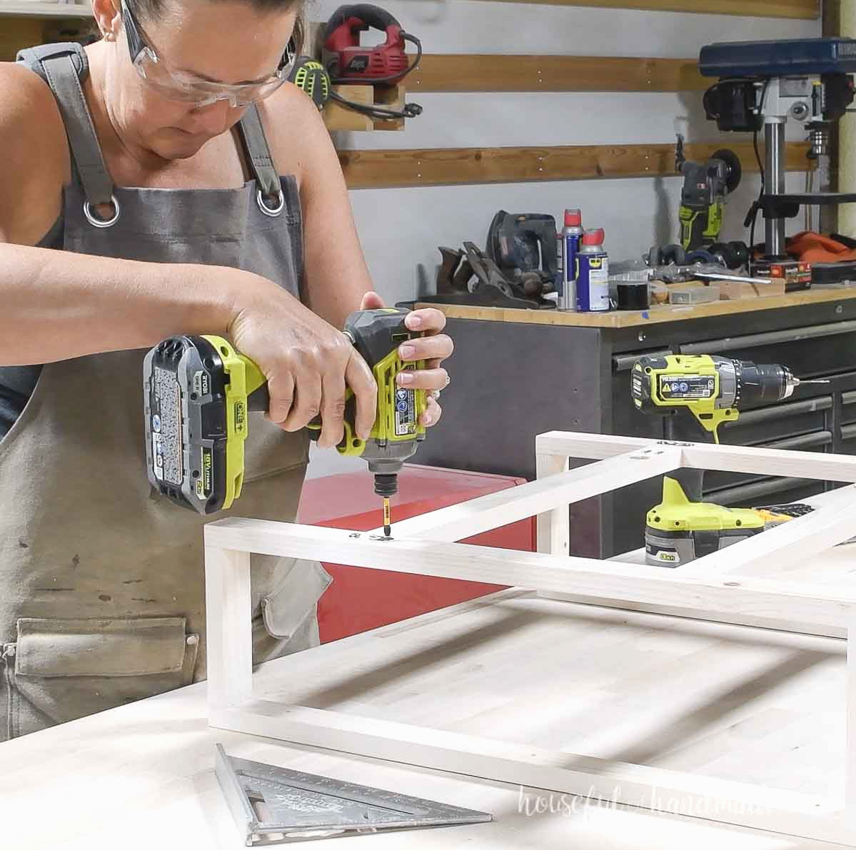 Installing keyhole hangers on the back of the wall shelf frame. 