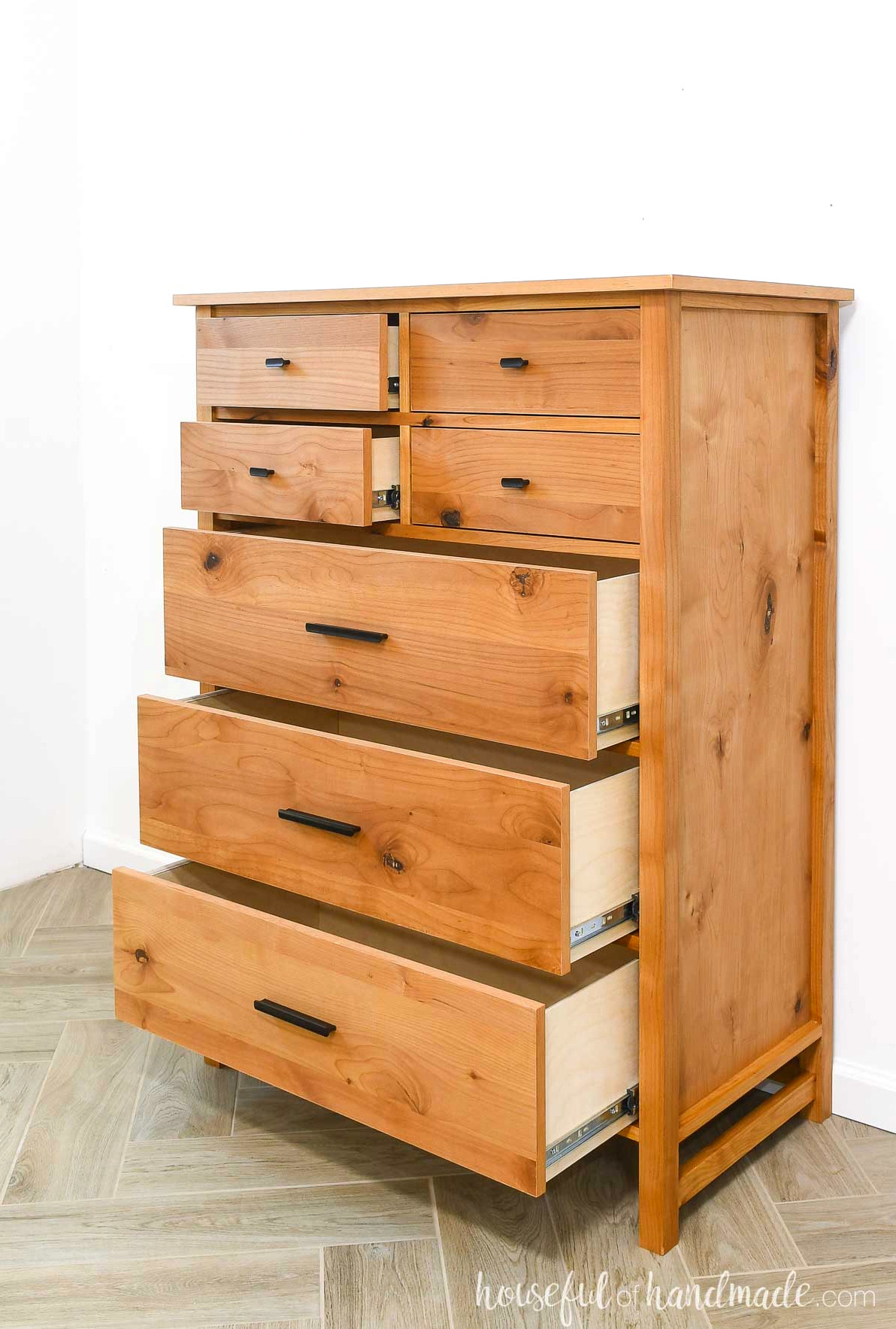 Warm wood dresser with 7 drawers slightly open to show the sides.