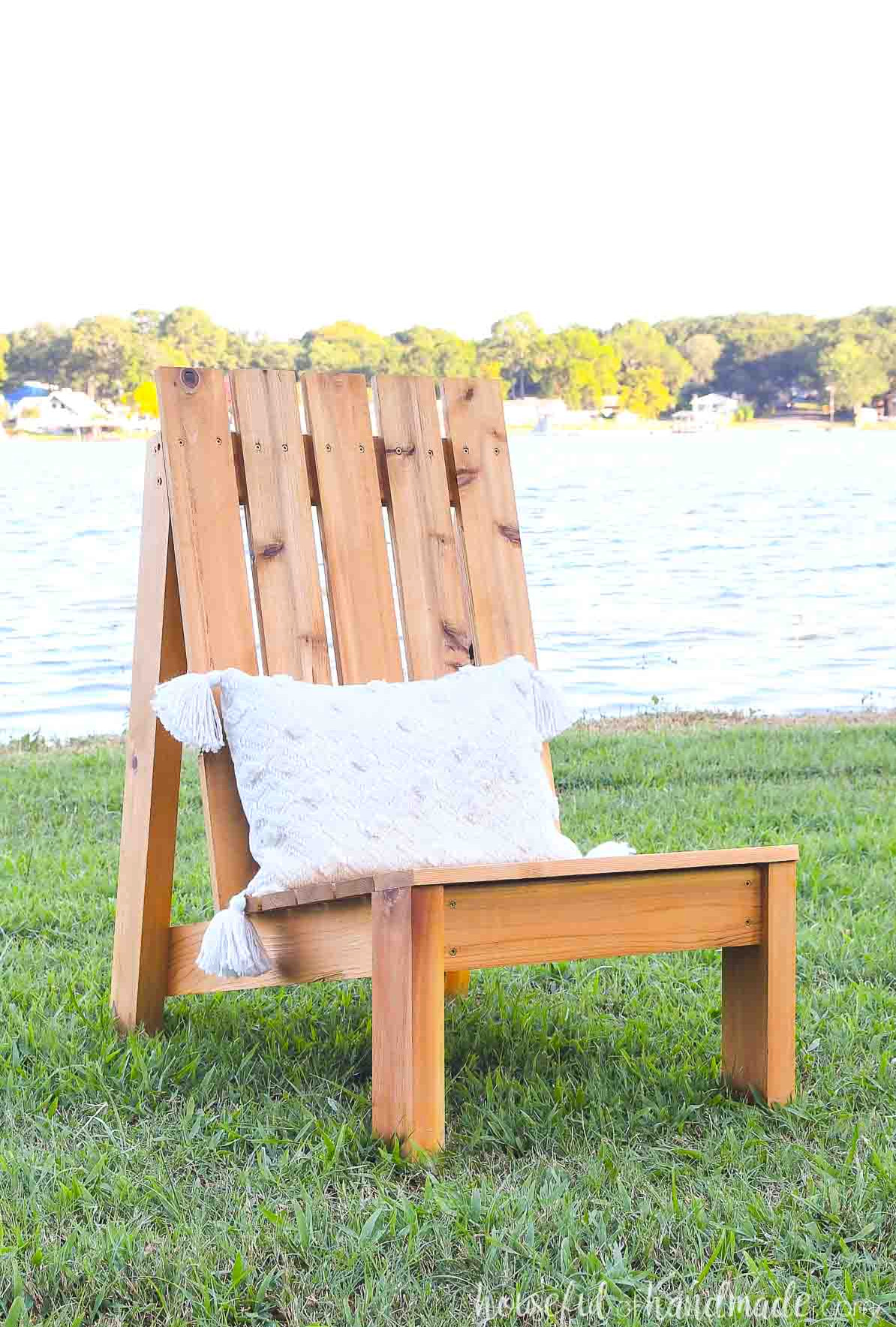 DIY cedar patio chair featuring a white lumbar cushion with tassels.