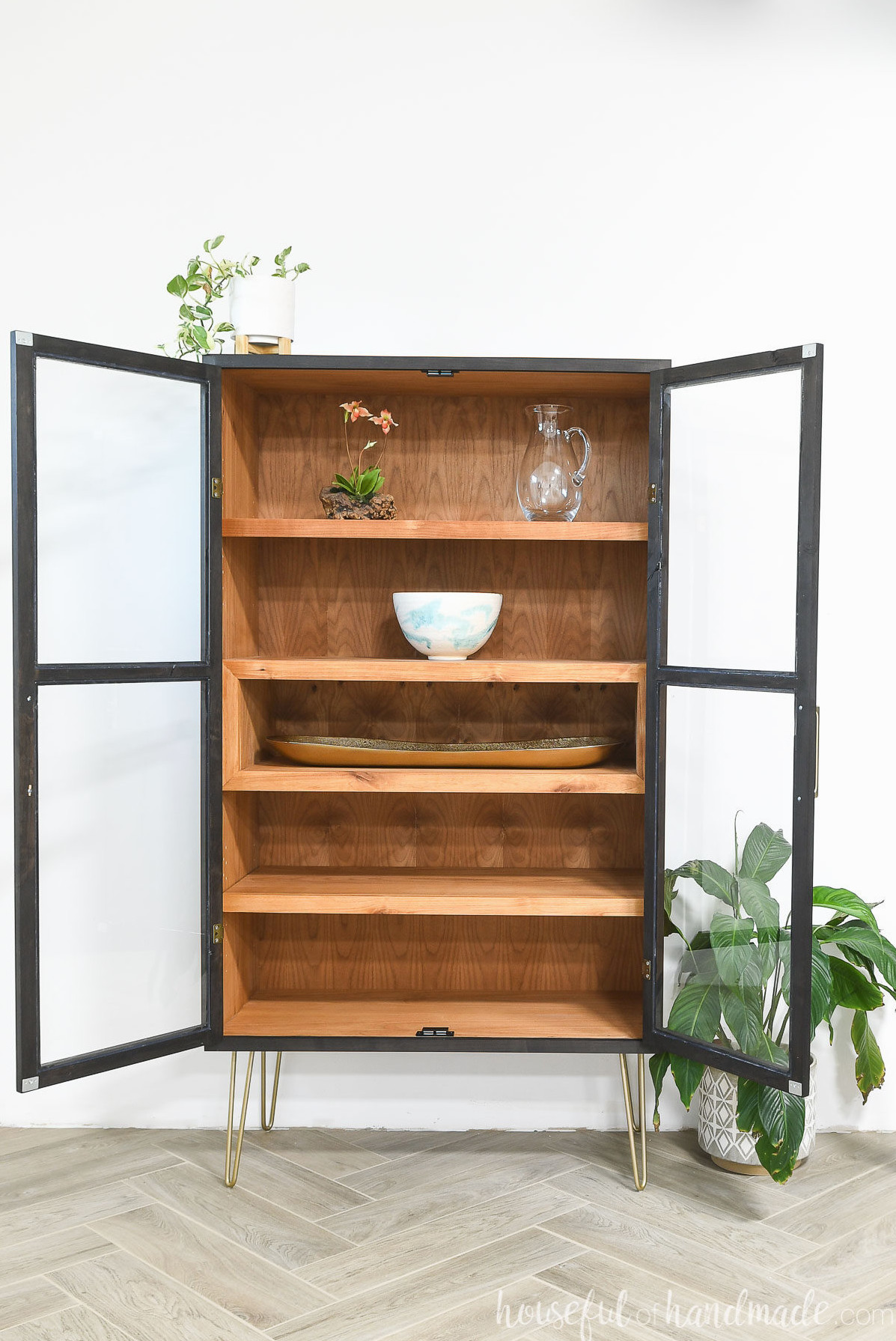 DIY curio cabinet with two open glass front doors and 4 shelves inside.