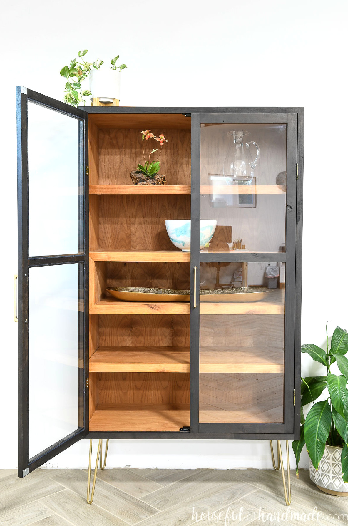 DIY contemporary display cabinet with alder wood on the inside and a black-stained exterior, two framed glass doors, and a display cubby. 