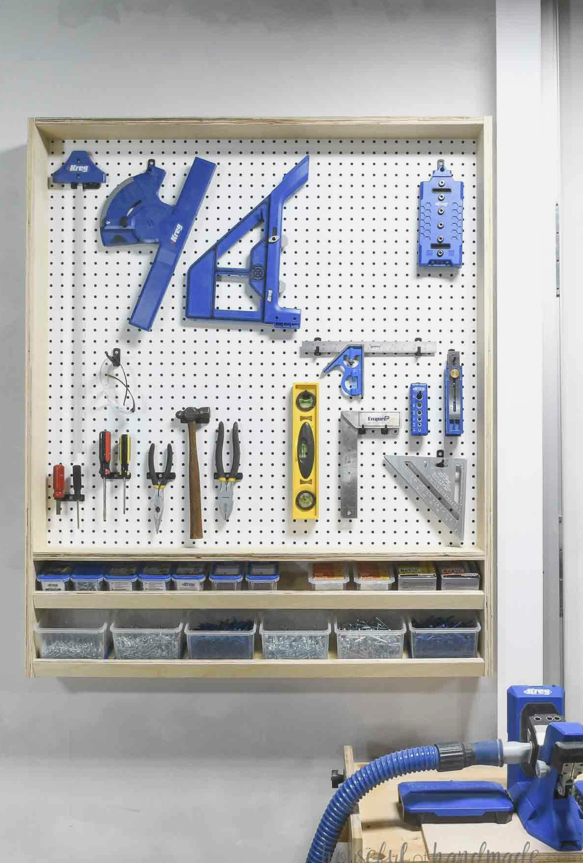 Shallow cabinet with a pegboard back and lower shelves arranging tools in a woodshop.