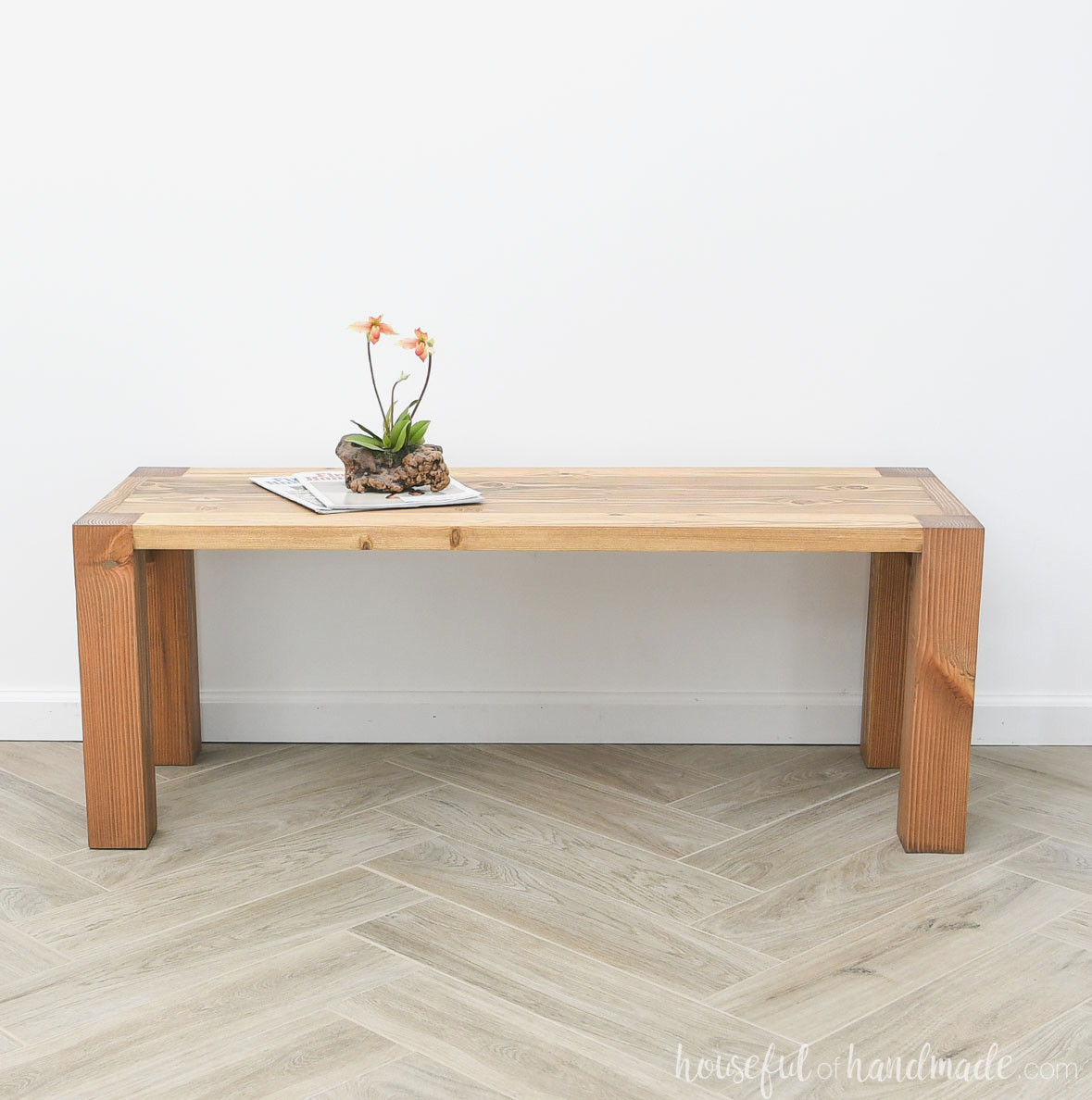 Stained wood coffee table with chunky legs cut into the top.