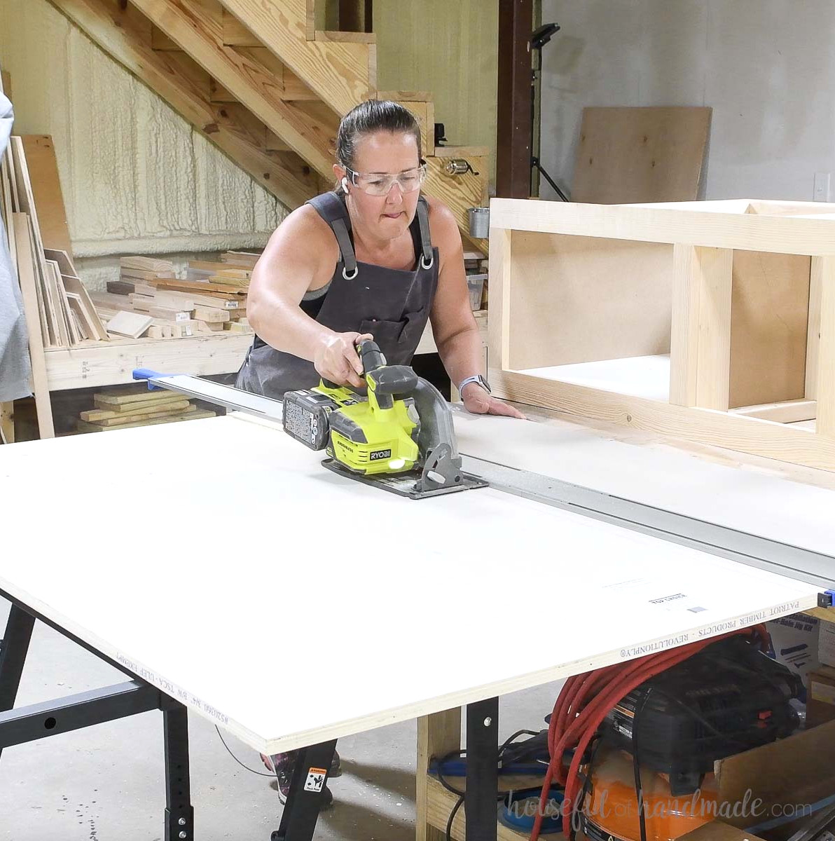 Cutting plywood with a circular saw using a straight edge guide.