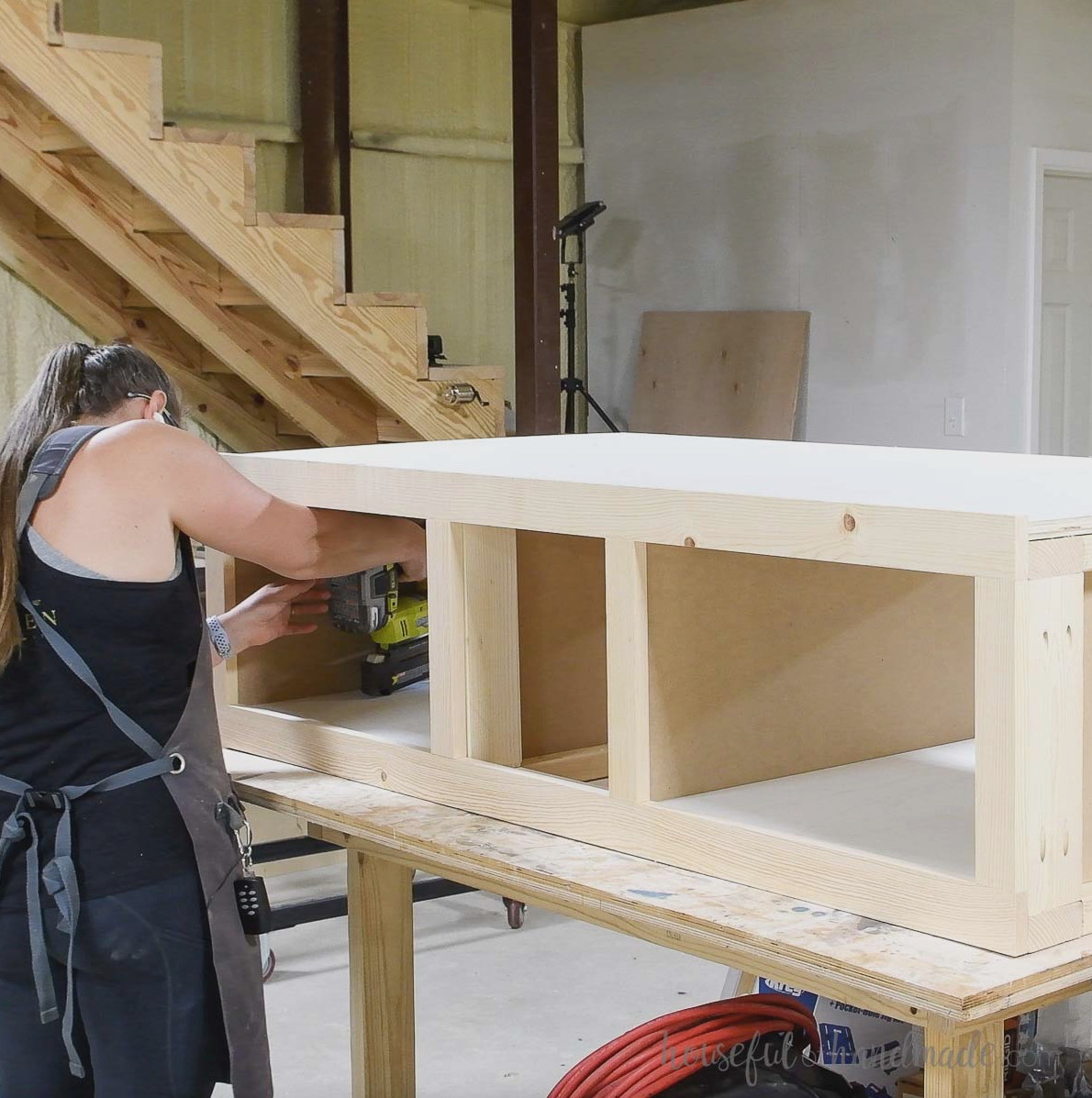 Attaching the plywood to the top of the pedestal and inside the shelves.