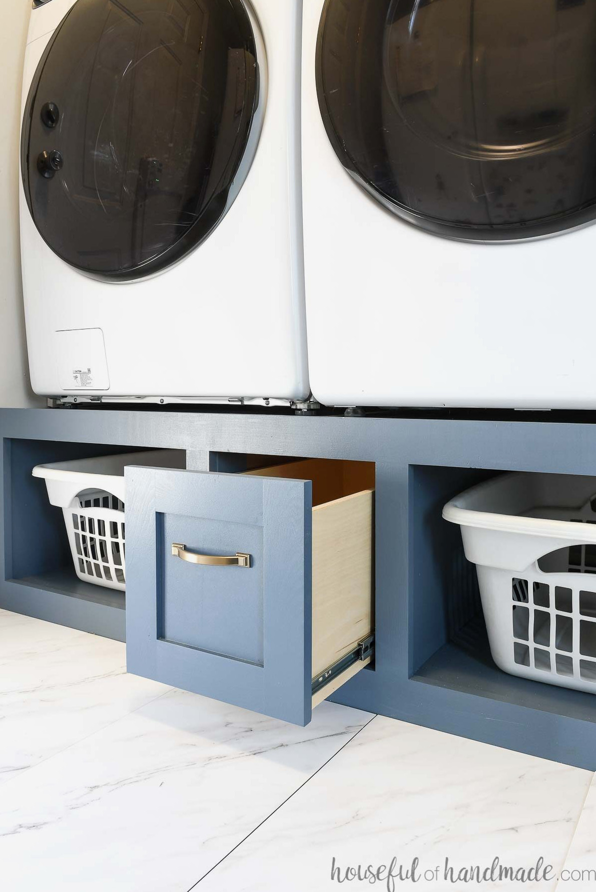 Washer and dryer platform with a drawer and shelves for storage.
