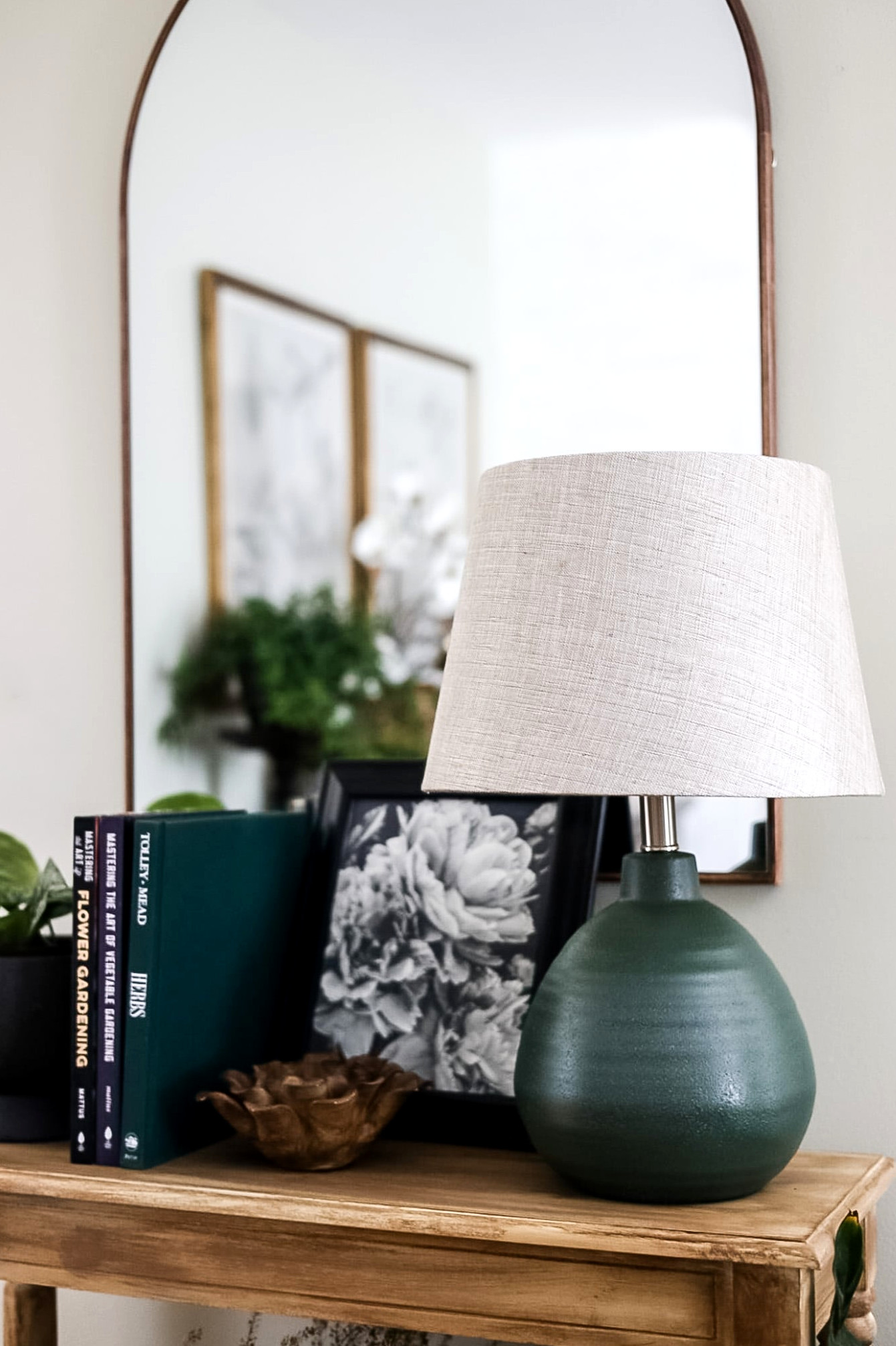 entryway table with green lamp and books