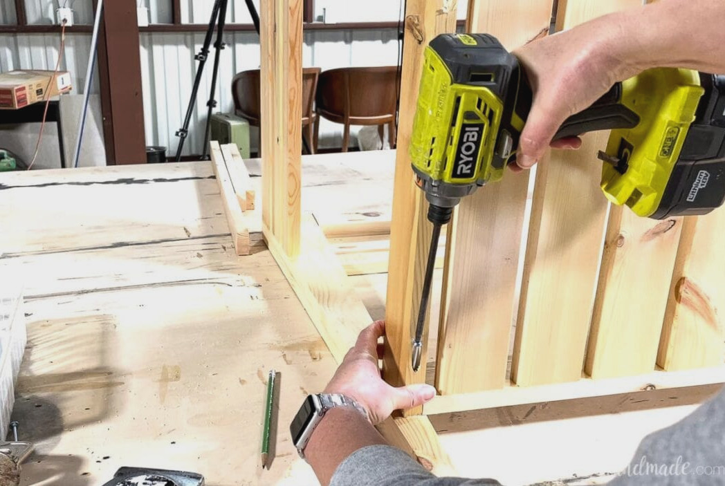Fastening the shelf to the open vanity legs through the pocket holes in the lower corners.