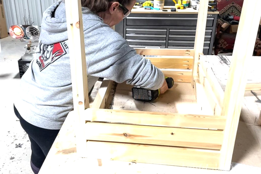 Fastening the completed back of the bathroom vanity to the side sections.