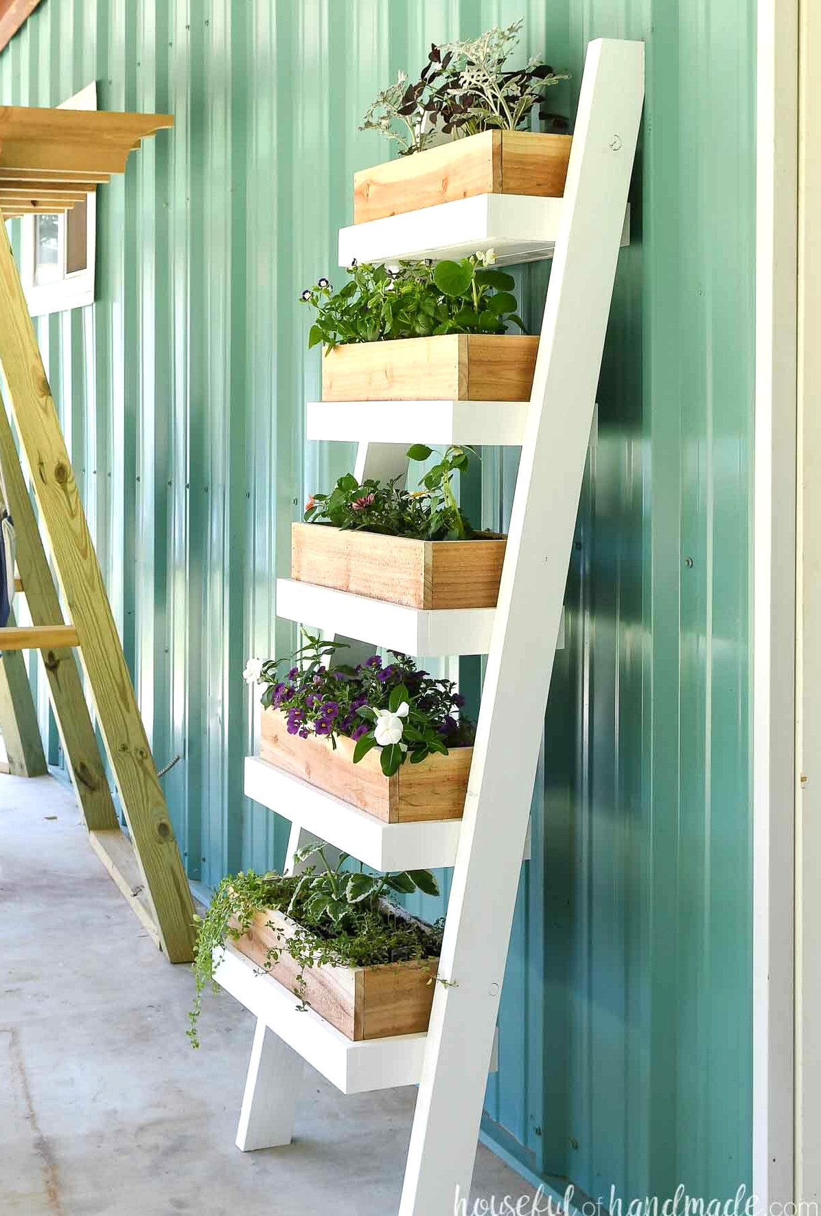 Side view of the DIY ladder planter featuring cedar boxes filled with flowers.