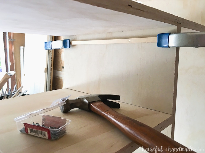 Showing the square dowel clamped and nailed inside the closet cubby.