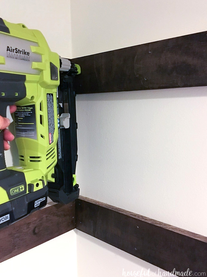 Using a Ryobi nail gun to fasten the shelf supports inside the closet.