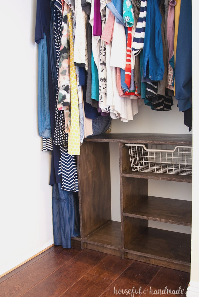 Personalized closet system built from plywood and stained walnut on one side, with clothing hanging above and beside it.