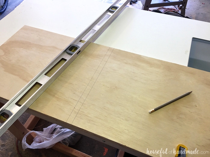 Shelf groove marked on the plywood with a level positioned beside it.