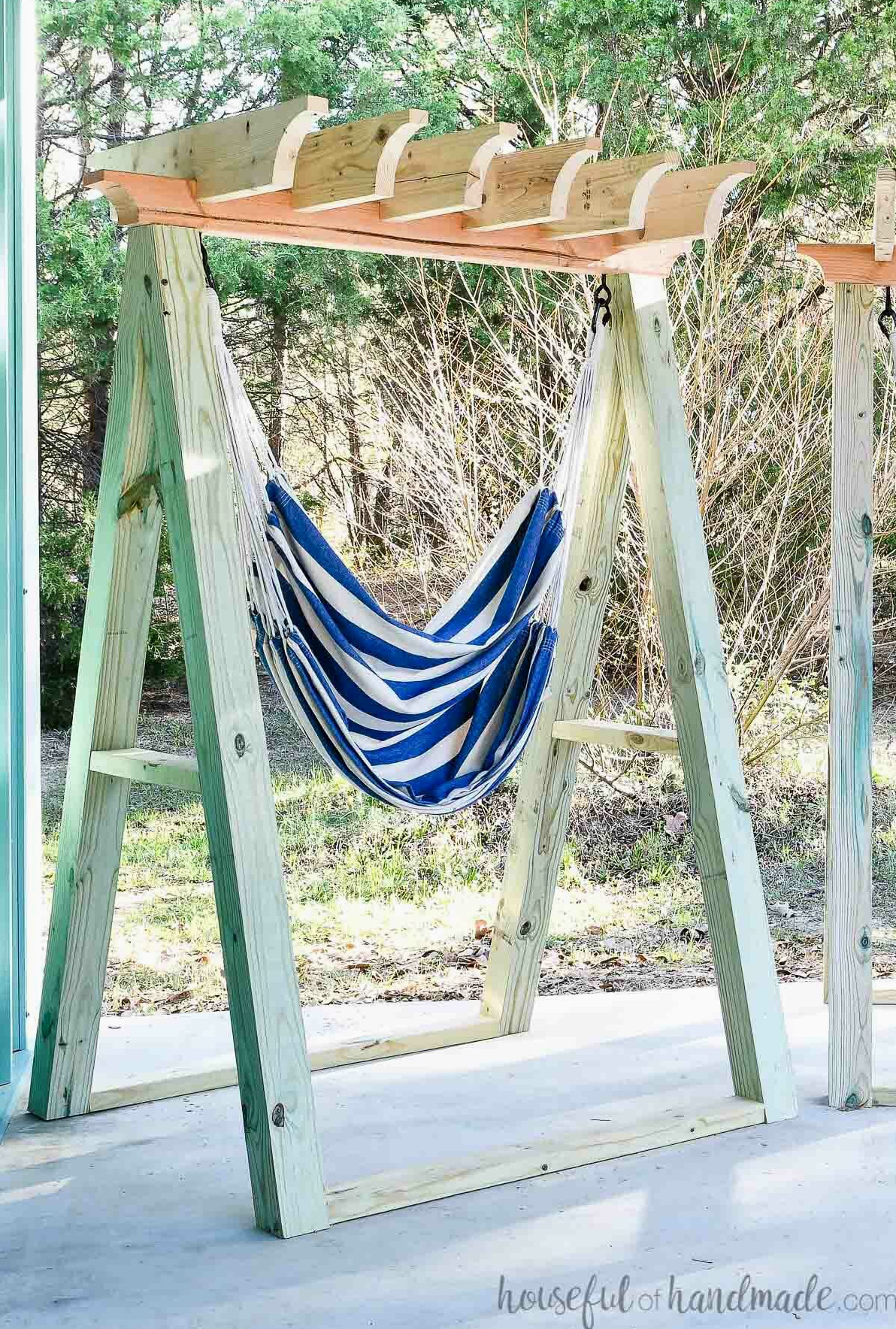 Hanging chair with stand featuring an A-frame built from 4x4 posts and a pergola roof for shade.