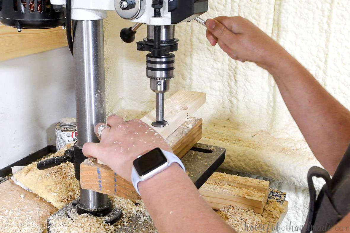 Drilling 1" holes in 2" wide pieces of wood with a drill press.