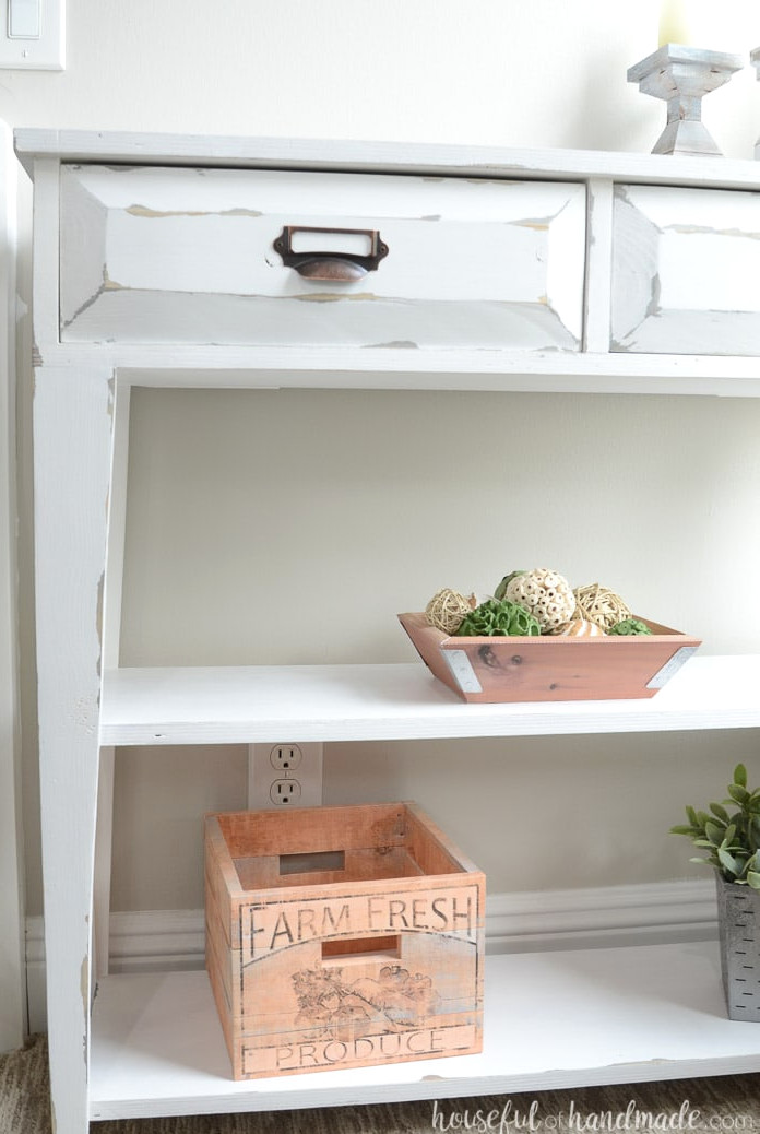 Build a beautiful small console table to add storage and decor to your home. This DIY farmhouse console table has two large drawers and two shelves. Perfect small space storage idea. Housefulofhandmade.com The tampered legs and open shelves give this small console table lots of farmhouse style. Housefulofhandmade.com