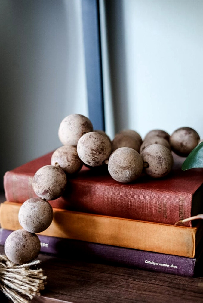 vintage books stacked with large wood bead garland