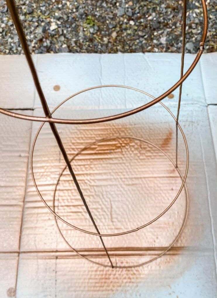 spray painting a tomato cage