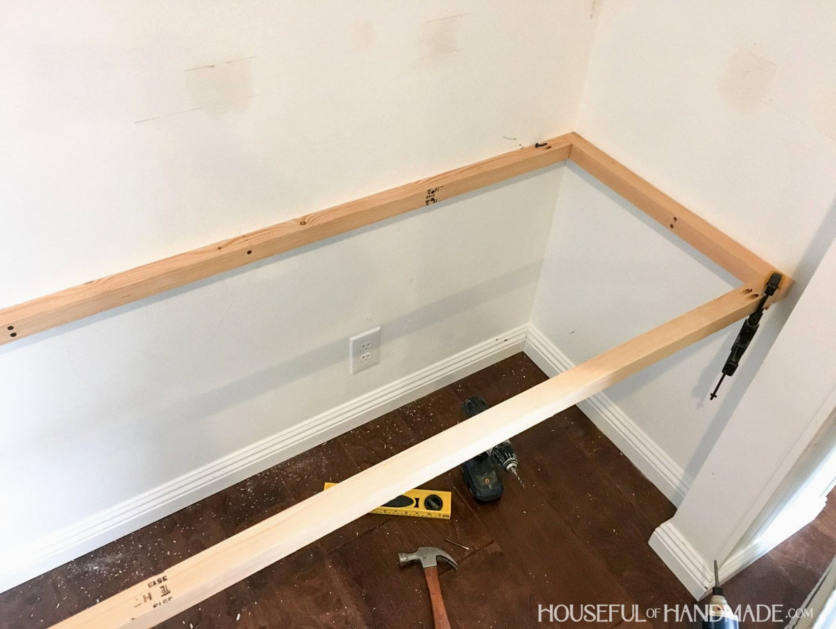 Desk frame secured inside a closet with 2x2 boards and pocket holes fastened at the ends.