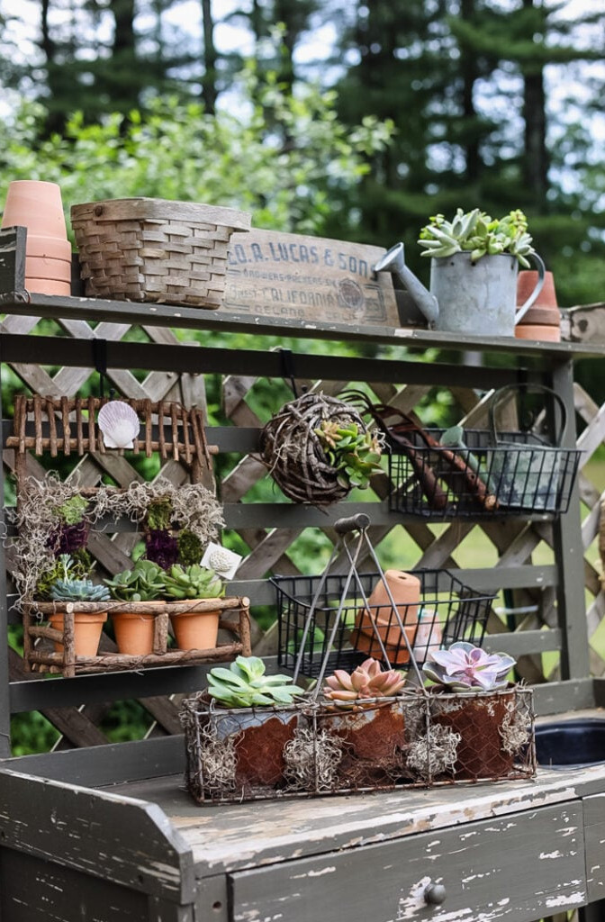 green potting bench filled with vintage finds and succulent planters