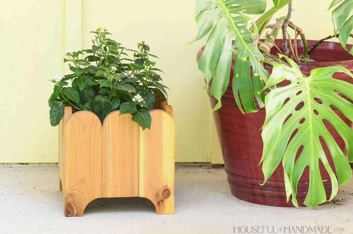 DIY wood planter box with plant inside on a porch. 