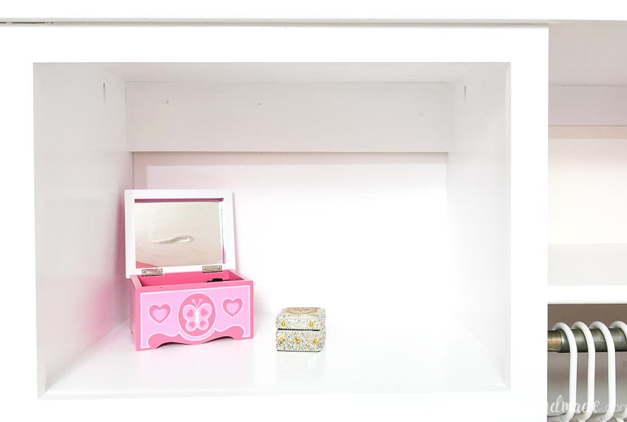 Close up view of the top open storage area on the closet system being used as a vanity space.