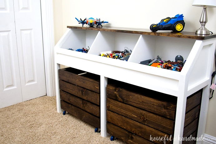 A stylish adult-inspired alternative to a toy box! Build a console table for arranging toys. This rustic toy storage unit features spacious open bins and rolling carts for plenty of storage. Find the free building plans. | Housefulofhandmade.com