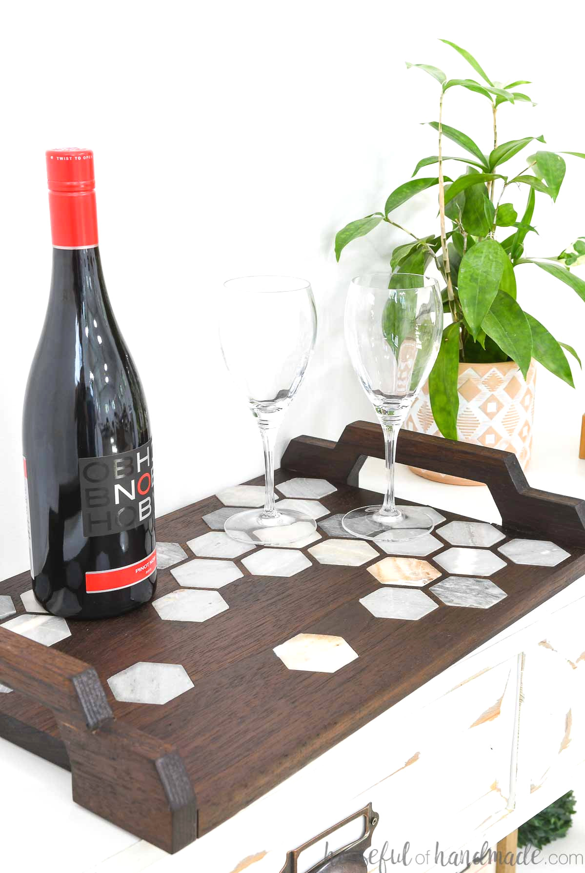 DIY walnut serving tray featuring a marble tile inlay and handles, topped with wine and glasses.
